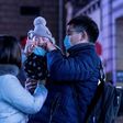 Parents put a protective mask on their baby outside Beijing railway station ahead of the Lunar New Year. State media has reported that a baby tested positive for the virus just 30 hours after being born