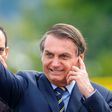 Brazilian President Jair Bolsonaro waves as he arrives for the hoisting of the national flag ceremony outside the Alvorada Palace in Brasilia, on January 21, 2020