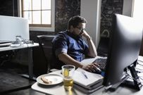 Creative businessman working and eating pizza and drinking beer at desk
