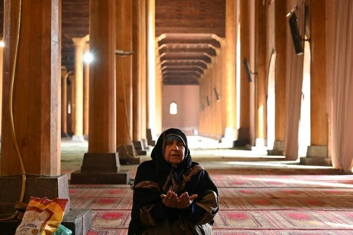 A woman prays in the main mosque in Srinagar after it opened for the first time in nearly five  months
