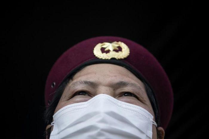 Security guards in Hangzhou take details from residents in order to enforce the limits on outbound trips