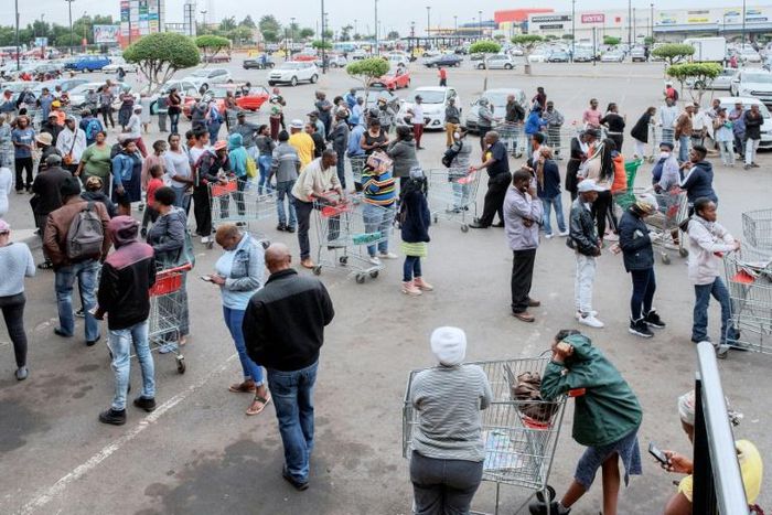 Shoppers stand in a queue as they wait to enter the Jabulani Mall in Soweto