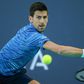 On the stretch: Novak Djokovic returns the ball to Karen Khachanov