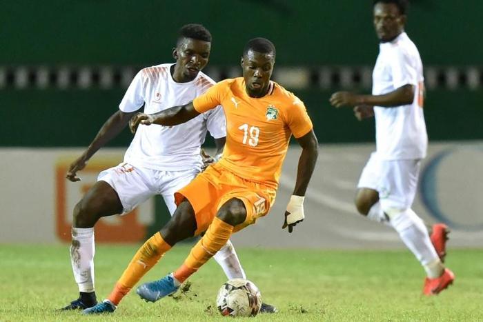 Ivory Coast forward Nicolas Pepe (C) controls the ball with Niger midfielder Mahamane Cisse behind him during an Africa Cup of Nations qualifier in Abidjan Saturday