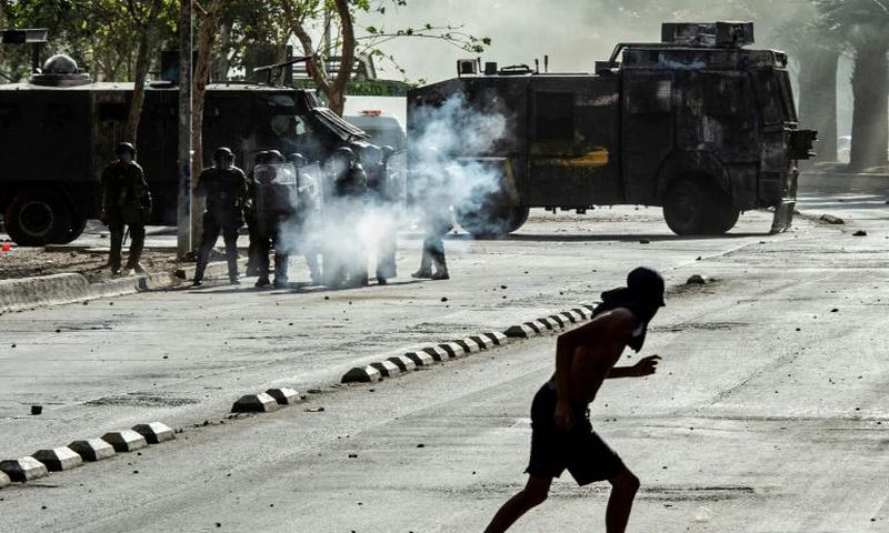 Demonstrators clash with riot police during a protest against President Sebastian Pinera's government in Santiago, on December 10