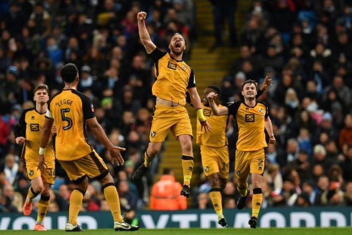 Port Vale striker Tom Pope (C) celebrates after scoring against Manchester City
