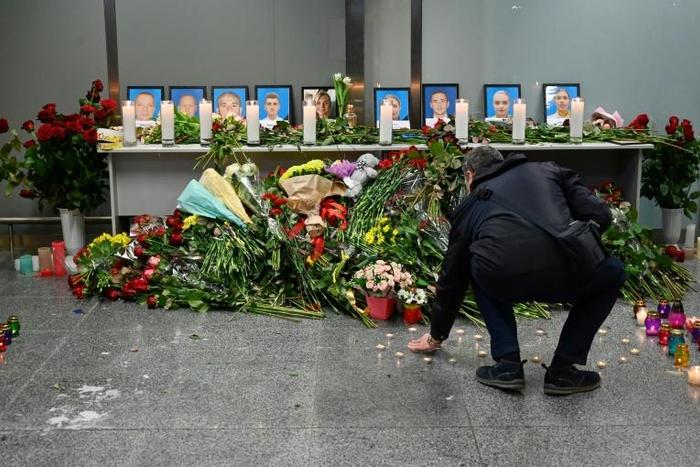 Dozens of people -- airline staff, passengers and locals alike -- gathered in the departure area to pay their respects to the crew, five men and four women