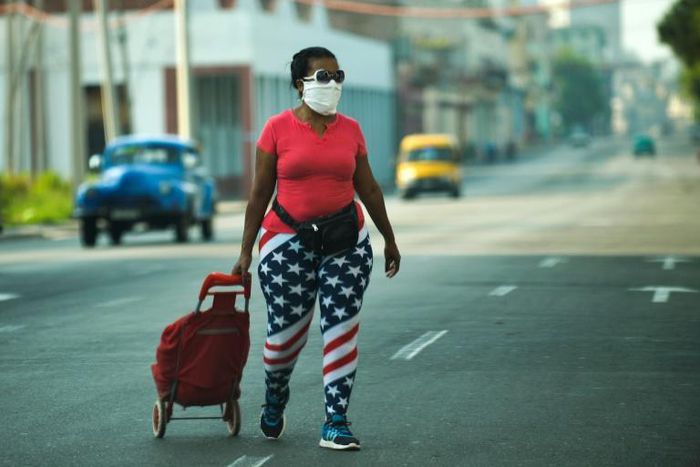 A woman wearing leggings depicting the US flag, walks along a street in Havana, on April 13, 2020