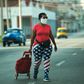 A woman wearing leggings depicting the US flag, walks along a street in Havana, on April 13, 2020