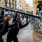 Anti-government protesters use a road sign to taunt security forces taking cover during clashes in the central downtown district in Beirut on Saturday