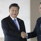 Brazil's President Jair Bolsonaro (R) and China's President Xi Jinping shake hands before the 11th BRICS Summit at the Itamaraty palace in Brasilia, Brazil