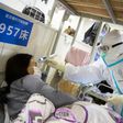 A health worker checks the temperature of a patient at a hospital in Wuhan