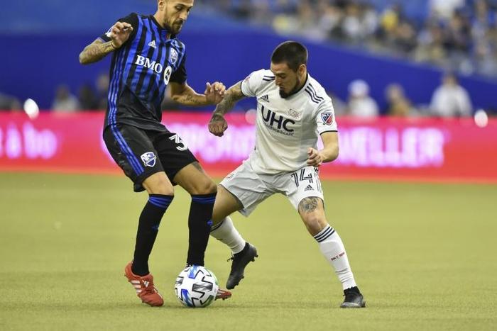 Montreal's Maxi Urruti (left) tackles New England's Diego Fagundez (right) in their season-opening Major League Soccer clash
