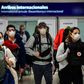 Passengers wearing face masks arrive at Ezeiza International Airport in Buenos Aires