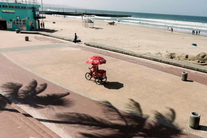 An optimistic ice cream vendor cycles along a deserted beach in Durban, South Africa. Tourism is one of the key African sectors hit by the coronavirus pandemic