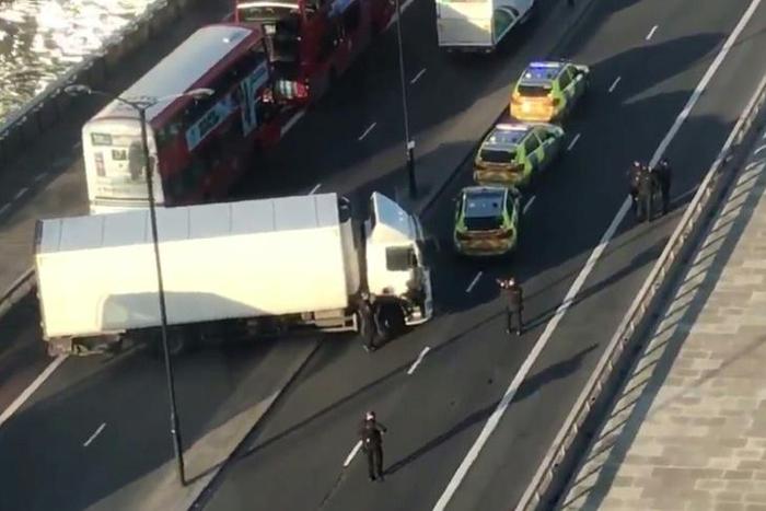 Armed police are shown surrounding a white van jackknifed across London Bridge after the incident