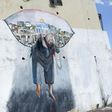 Schoolgirls walk past a mural in the Arab-Israeli town of Umm al-Fahm north of Tel Aviv