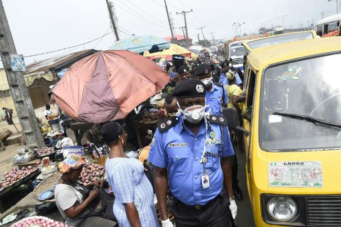 Lagos Police Commissioner Hakeem Odumosu squeezes his way through a market to monitor compliance with  measures to curb the spread of coronavirus
