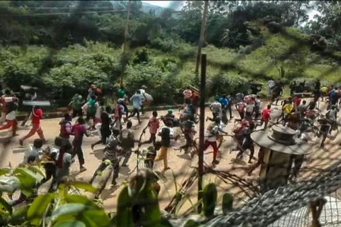 This frame grab taken from video footage on Monday shows crowds fleeing with items after they stormed a United Nations compound