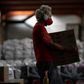 A man carries a box while organizing 40 tons of food and supplies to be delivered to residents of favelas in Rio de Janeiro, Brazil, on April 9, 2020