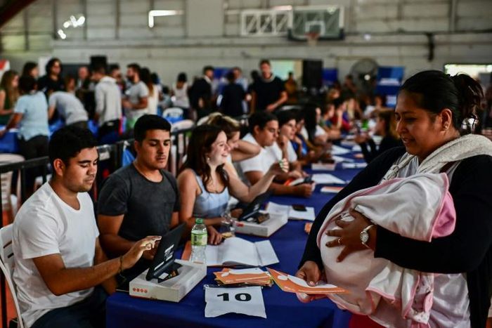 A woman with a baby collects a government-issued food card in Lomas de Zamora, close to the capital Buenos Aires