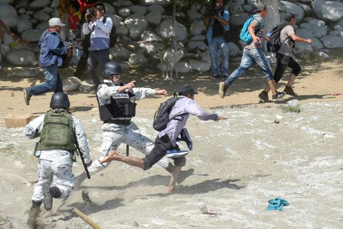 Mexican National Guards tackle migrants who   crossed the Suchiate River from Guatemala on January 20, 2020