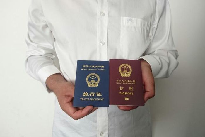 An unidentified Chinese Uighur man in the city of Medina holds his expired Chinese passport (red) and a one-way travel document (blue) issued in its place by the Chinese mission in Saudi Arabia