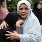 Relatives of three Thai men killed after being mistaken for militants comfort each other while waiting for the bodies of their loved ones to be released