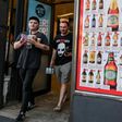 Two men leave a so-called "bottle shop" in Melbourne after major alcohol retailers in Australia agreed to enforce new rules limiting individual purchases