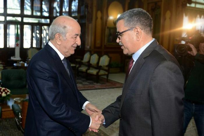 A handout picture released by the official Algeria Press Service (APS) shows Algerian President Abdelaziz Tebboune (L) receiving the newly appointed Prime Minister Abdelaziz Djerad in the capital Algiers on December 28, 2019
