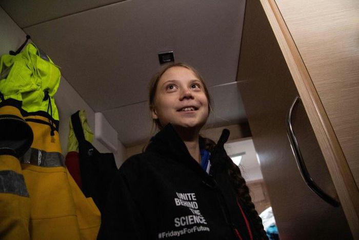 Greta Thunberg wore an oversized black windbreaker emblazoned with the words "Unite Behind The Science" as heavy, freezing rain pounded the hull of the sailboat she is traveling on to Europe