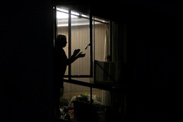 A woman in Buenos Aires, Argentina claps her hands to express gratitude to health workers, a nightly tradition during the "preventative and compulsory" lockdown