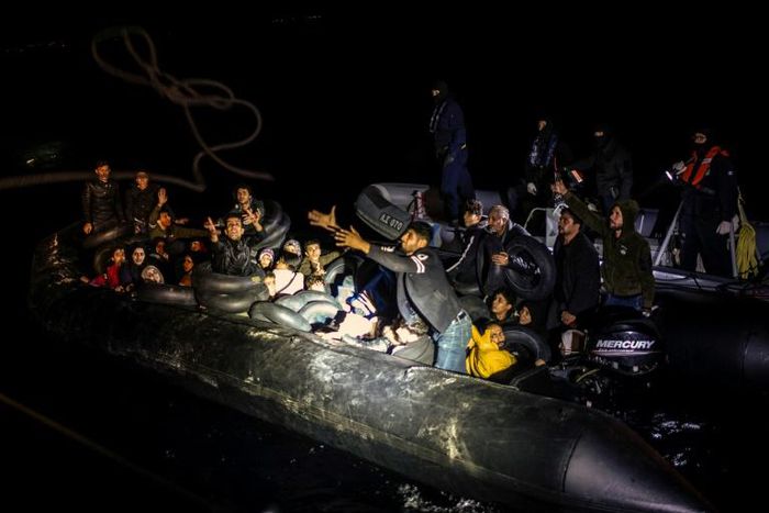 From a distance, just a handful of people can be seen sitting on the sides of the dinghy, but it soon becomes clear that it is packed