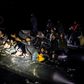 From a distance, just a handful of people can be seen sitting on the sides of the dinghy, but it soon becomes clear that it is packed
