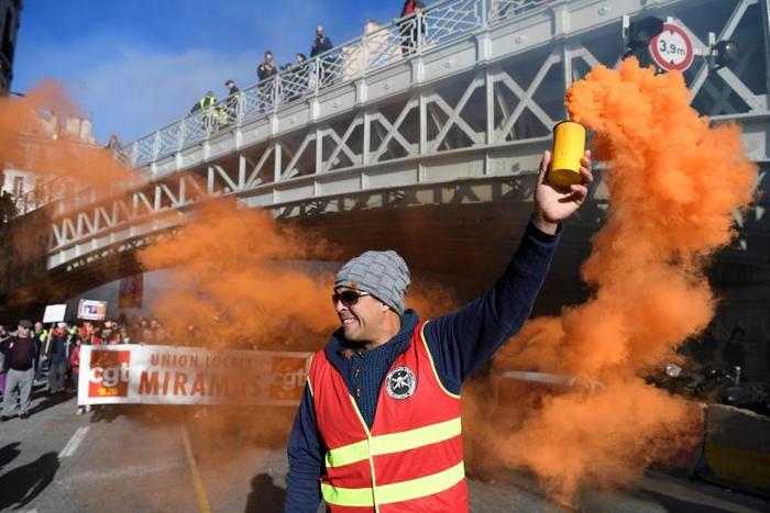 Protests were staged in Paris, Marseille, Toulouse, Nantes and other cities. Here a protester wields a smoke bomb in Marseille