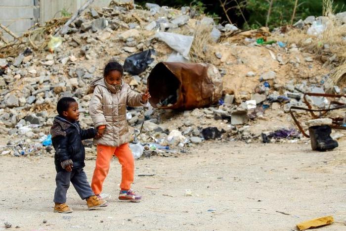 Libyan children play outside an unfinished building which has become home to many displaced families in Tripoli