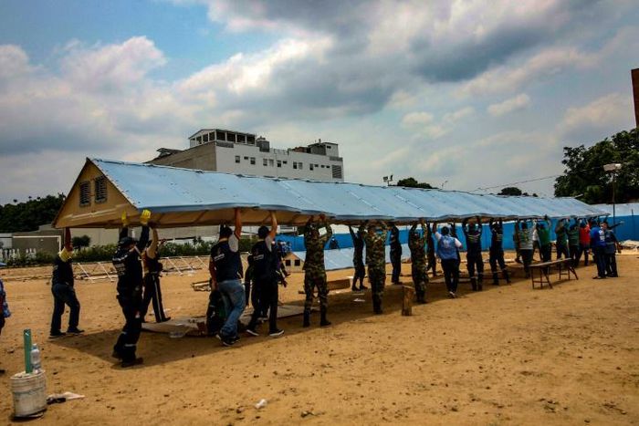 Firefighters, soldiers and workers from the office of the United Nations High Commissioner for Refugees (UNHCR)setting up a field hospital for coronavirus cases on the border with Venezuela, on March 28, 2020