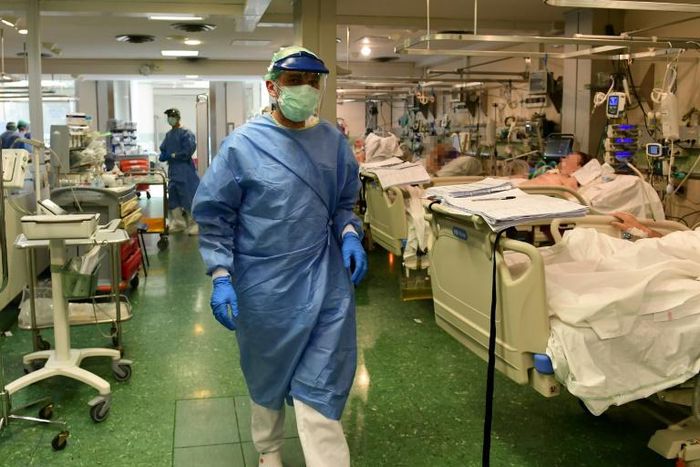A man in a facemask stands on his balcony in Havana, Cuba
