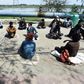 Homeless Indians sit in "isolation circles" outside a shelter while waiting for food in New Delhi