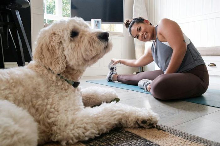 Singaporean Alison Yuen takes an online fitness class in her Hong Kong home, watched by her golden labradoodle Whelan