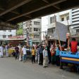 People queue to collect subsidised food in Dhaka