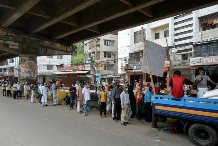 People queue to collect subsidised food in Dhaka