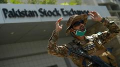 A paramilitary soldier gestures while standing guard outside the Pakistan Stock Exchange  after gunmen attacked the building