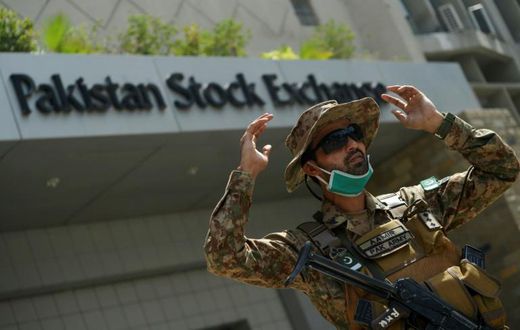 A paramilitary soldier gestures while standing guard outside the Pakistan Stock Exchange  after gunmen attacked the building