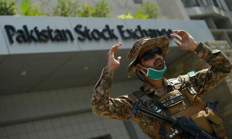A paramilitary soldier gestures while standing guard outside the Pakistan Stock Exchange  after gunmen attacked the building