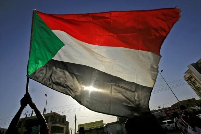 The Sudanese flag flies in Khartoum during a commemoration of a deadly raid a year ago on an anti-government sit-in
