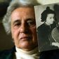 Holocaust survivor Anita Lasker-Wallfisch, pictured here in 2005, holds up a portrait of herself playing the cello in Berlin before World War II
