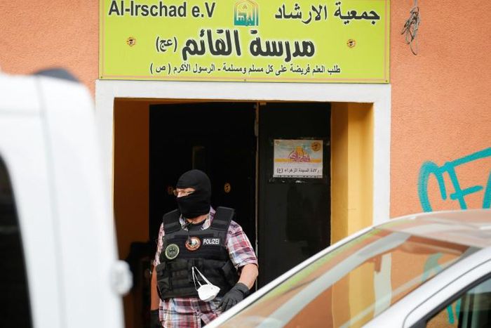A police officer walks out of Al-Irschad Mosque during a raid in Berlin, as dozens of police and special forces stormed mosques and associations linked to Hezbollah in Bremen, Berlin, Dortmund and Muenster early Thursday.