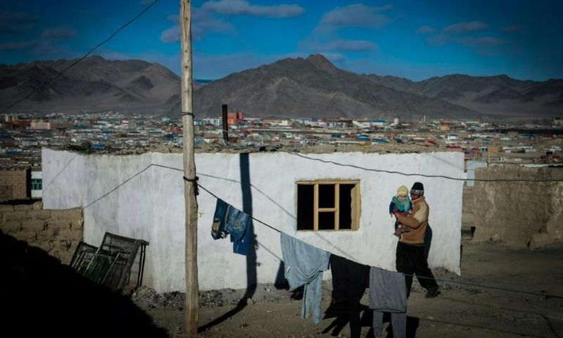 A man carries a child in the center of Bayan-Ulgii, a province of Mongolia bordering Russia and China  which has seen two bubonic plague cases