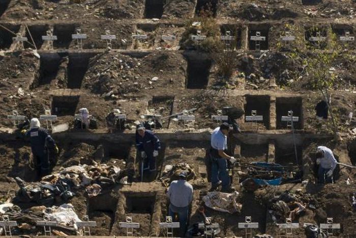 Workers dig graves in Santiago's General Cemetery after health authorities ordered them to prepare for a possible surge in deaths from COVID-19